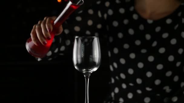 Naplnění sklenice červené víno. Ženy vypít sklenku červeného vína v temnu. Slavnostní atmosféra. Zpomalený pohyb