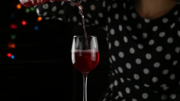 Vino rosso che riempie un bicchiere. Donne che bevono un bicchiere di vino rosso al buio. atmosfera festiva. rallentatore — Video Stock