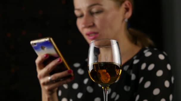 Donna felice che parla al cellulare e beve vino al buio. atmosfera festiva e concetto di celebrazione. rallentatore — Video Stock