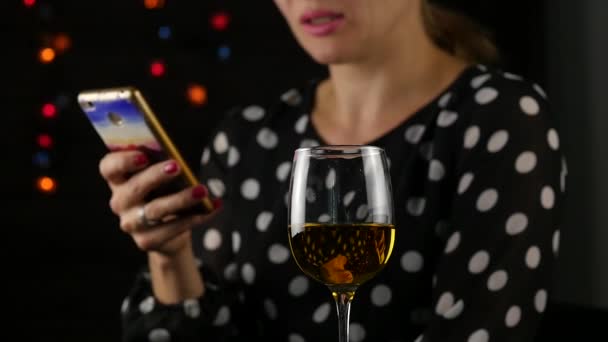 Encantadora mulher usa celular e bebe vinho branco. bela senhora comemorando e enviar uma mensagem. câmara lenta — Vídeo de Stock