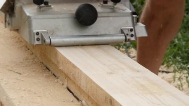 planya makinesi bir ahşap üzerine çalışan adam. Cips planer farklı taraftan uçakla. ağır çekim