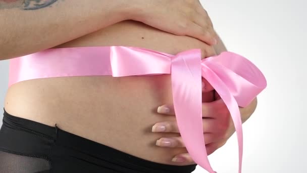 Gravid kvinna med ett rosa band på hennes mage. slowmotion — Stockvideo