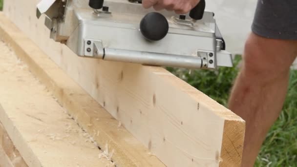 Los trabajadores del taller utilizan la máquina de cepillado de madera. Las virutas vuelan en diferentes lados de la cepilladora. cámara lenta — Vídeo de stock