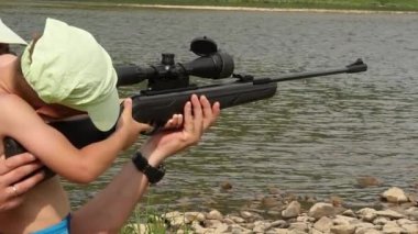 Çocuk bir havalı tüfek ateş optik görme ile öğrenir. ağır çekim