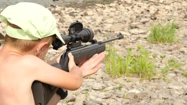 Niño aprende a disparar una pistola de aire comprimido con mira óptica. cámara lenta — Vídeos de Stock