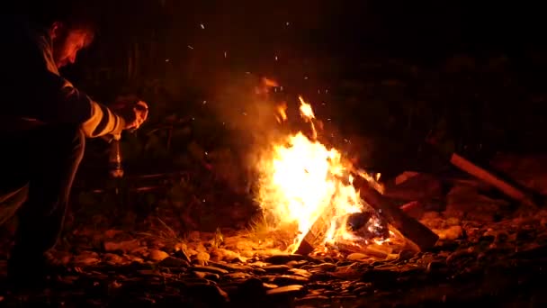 Bearded men resting and make a photo on a cellphone of bonfire in a dark. 4K — Stock Video