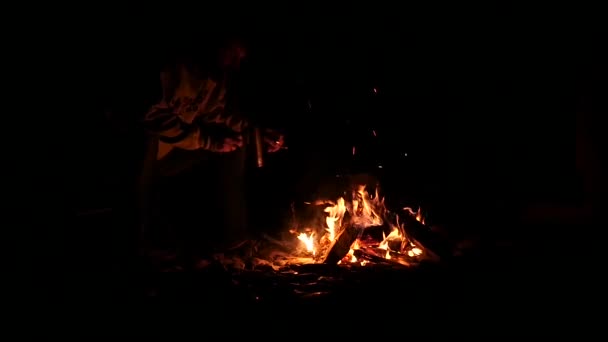Bearded men drink tea from big cup and make a photo on a cellphone of bonfire in a dark. slow motion — Stock Video