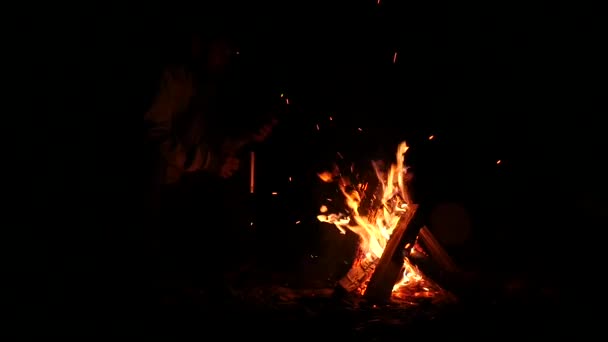 Bearded men drink tea from big cup and make a photo on a cellphone of bonfire in a dark. slow motion — Stock Video