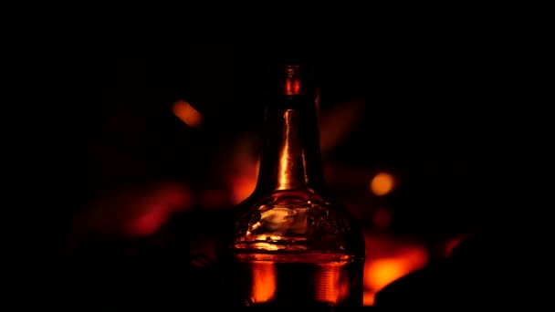 Beer bottle on a fire background in a dark. flame game on brown glass. 4K — Stock Video