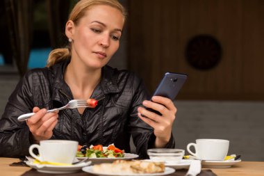 salata açık bir kafede yemek işkadını. Sağlıklı yaşam tarzı: yeşil lezzetli yiyecek ve kontrol e-posta üstünde senin telefon yeme kız