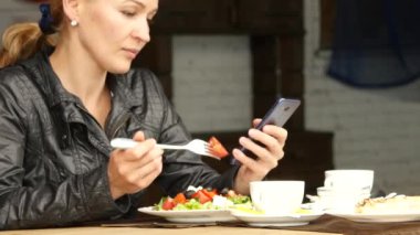 salata açık bir kafede yemek işkadını. yeşil lezzetli yiyecek ve kontrol e-posta üstünde senin telefon yeme kız. 4k