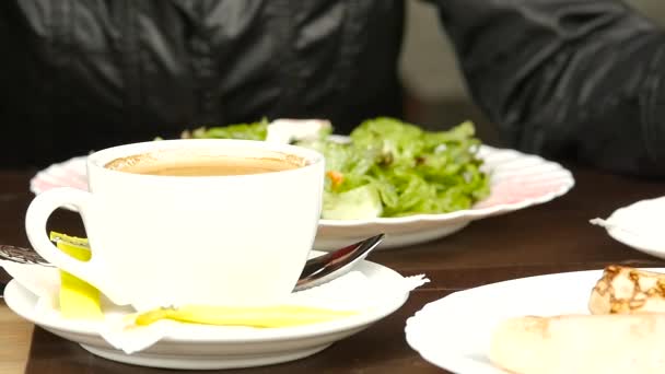Empresaria comiendo ensalada en un café al aire libre. Estilo de vida saludable: niña comiendo comida sabrosa verde. cámara lenta — Vídeo de stock