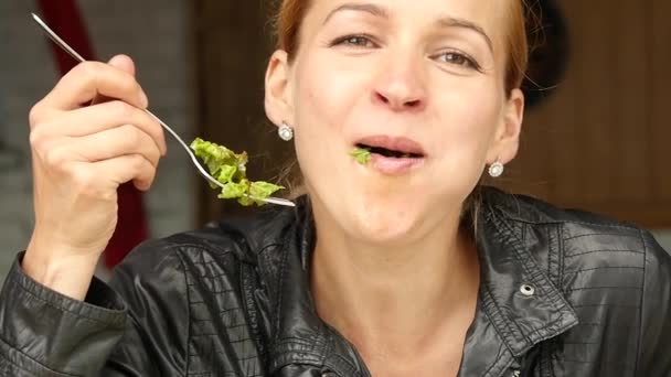 Salata açık bir kafede yemek işkadını. Sağlıklı yaşam tarzı: yeşil lezzetli yemek yeme kız. ağır çekim — Stok video