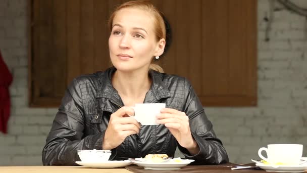 Hübsche Frau essen ein Mittagessen auf der Sommerterrasse, Mädchen aus nächster Nähe trinken Kaffee oder Tee. Zeitlupe — Stockvideo