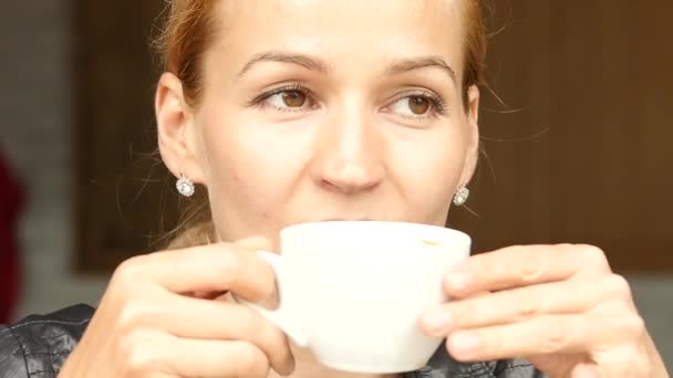 Привлекательная деловая женщина пьет кофе и отдыхает в открытом кафе на летней террасе. замедленное движение — стоковое видео