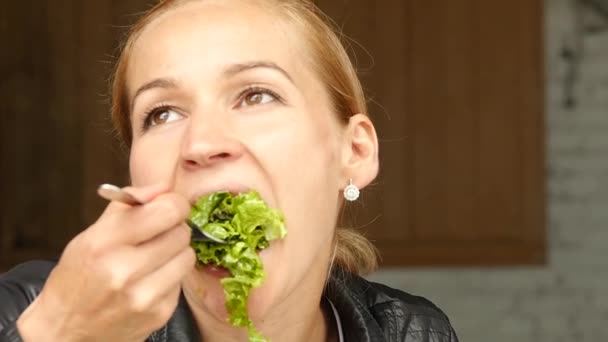 Деловая женщина ест салат в кафе на открытом воздухе. Здоровый образ жизни: девушка ест зеленую вкусную еду. замедленное движение — стоковое видео