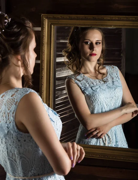 Jeune femme élégante devant miroir, or et bois — Photo