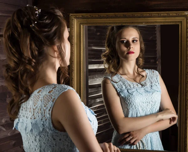 Jeune femme élégante devant miroir, or et bois — Photo