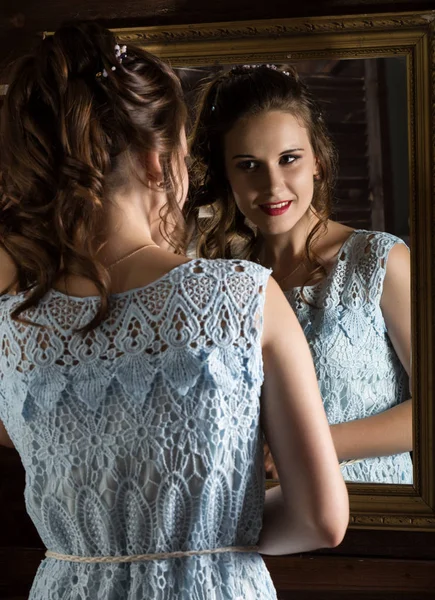 Jovem mulher elegante na frente do espelho, ouro e madeira — Fotografia de Stock