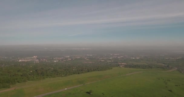 Flygfoto. lantlig väg bland fält, landsbygden vägen mellan grönt fält med smog. luftföroreningar runt industristaden. 4k — Stockvideo