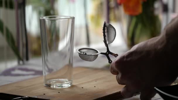 Uomo preparare il tè con un bicchiere di acqua calda e infusore di tè. rallentatore — Video Stock