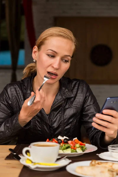 屋外のカフェでランチ。あなたの携帯電話にサラダとチェック メールを食べて実業家 — ストック写真