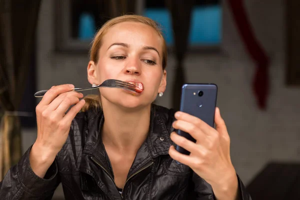 Empresaria comiendo ensalada en un café al aire libre. Estilo de vida saludable: chica comiendo comida sabrosa verde y cheques de correo electrónico en su teléfono —  Fotos de Stock