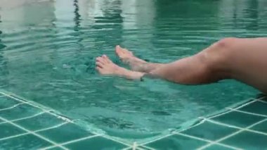 Genç kadının Otel havuzunda rahatlatıcı yakın çekim bacaklar