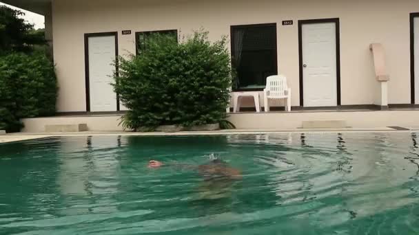 Ragazza che gioca con l'acqua in una piscina d'albergo. Ragazzo divertirsi in acqua all'aperto — Video Stock