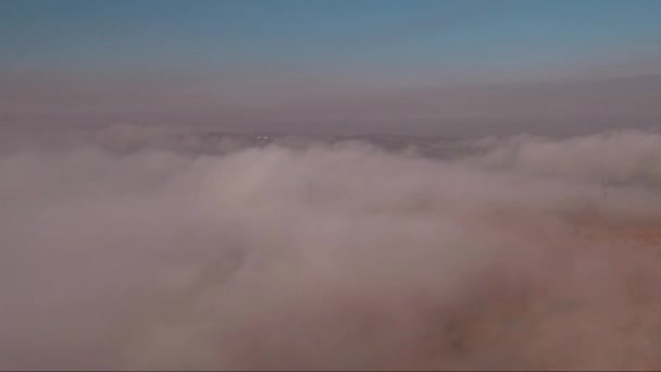 Luftaufnahme, Flug durch und über den Nebel bei Sonnenuntergang, Landschaft mit einer Straße — Stockvideo