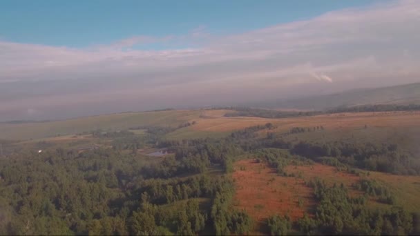 Vista aerea, volo attraverso e sopra la nebbia al tramonto, campagna con una strada — Video Stock