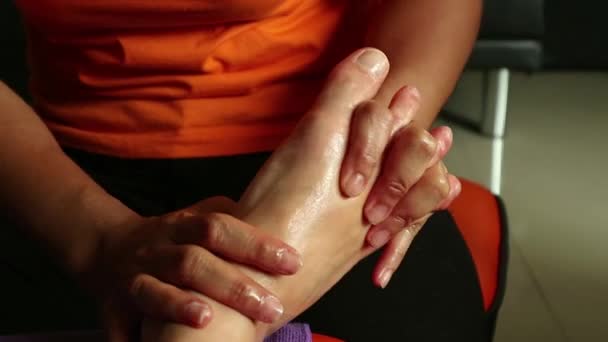 Wanita muda pijat kaki di salon spa kecantikan. close-up womans legs and masseurs hands — Stok Video