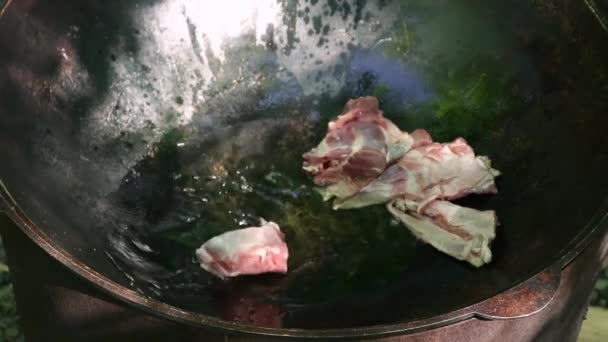 Cucina di pilaf all'aperto. Agnello tritato che frigge nel calderone. Concetto campeggio — Video Stock