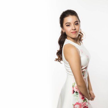 Beyaz elbiseli güzel esmer kadın omuz dışında beyaz arka plan üzerinde görünüyor. Metniniz için boş alan