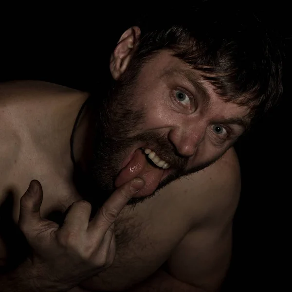 Homem barbudo assustador mostrando o dedo médio. estranho russo homem com um torso nu e um chapéu de lã . — Fotografia de Stock