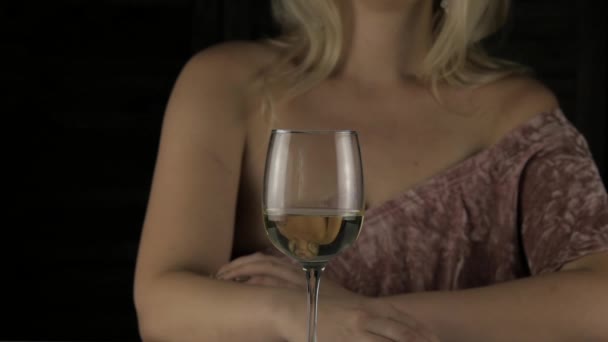 Close-up blonde vrouw drinkt champagne alleen in het donker. eenzame luxe meisje in restauran. Slow motion — Stockvideo