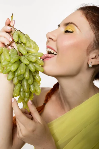 Hermosa pelirroja está comiendo uvas. concepto de alimentación saludable — Foto de Stock