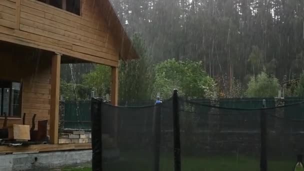 Ducha de lluvia fuerte en el patio trasero en la casa sin terminar. cámara lenta — Vídeo de stock