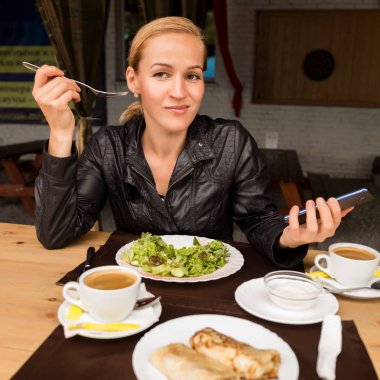 salata açık bir kafede yemek işkadını. Sağlıklı yaşam tarzı: yeşil lezzetli yemek yeme kız