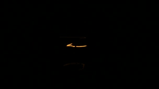 Light bulb turning on and off on black background, slow motion — Stock Video