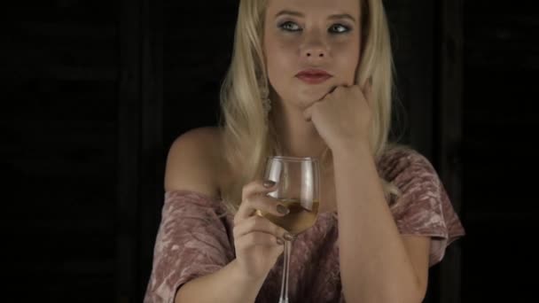 Jovem mulher loira impaciente bebendo vinho tinto e esperando por um encontro no café. câmara lenta — Vídeo de Stock