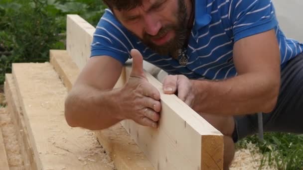 Der junge bärtige Tischler prüft die Qualität der Bretter. Zeitlupe — Stockvideo