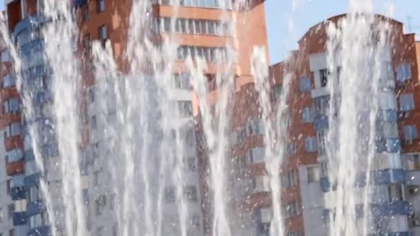 Los arroyos del agua de la fuente sobre el telón de fondo del edificio de la ciudad en el día soleado. cámara lenta — Vídeo de stock