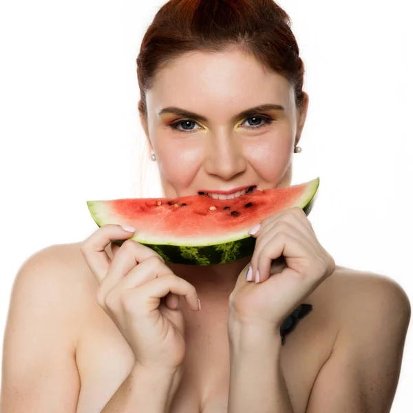 Mooi naakt roodharige vrouw eten een stukje watermeloen. begrip van gezond eten — Stockfoto