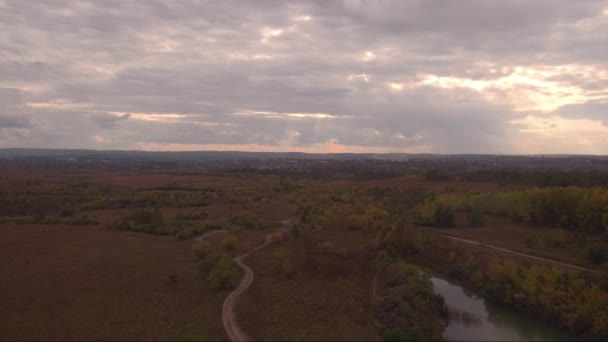 Вид: Політ над сільською дорогою з невеликим озером, грозові хмари на горизонті — стокове відео