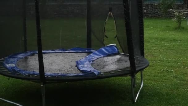 Yağmurda Trambolin ile Çocuk oyun alanı. ağır çekim — Stok video