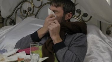 Bir soğuk veya grip sırasında burun akıntısı sahip olarak onun burun üfleme hasta bir adam. ağır çekim