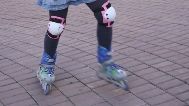 Τα πόδια του παιδιού σε πατίνια. Παιδί ρολά στο πάρκο pablic. Αργή κίνηση — Αρχείο Βίντεο