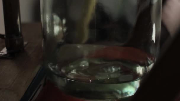 Alcohol destillatie apparatuur, hooch vloeistofstromen in glazen pot — Stockvideo