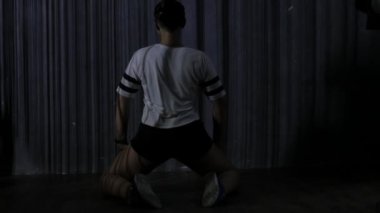 Genç kadın twerk dans. bir gövde üzerinde çizgili gölgeler. Ağır çekim